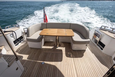 Luxurious 2022 Princess F50 yacht deck with seating and table, cruising on open water.