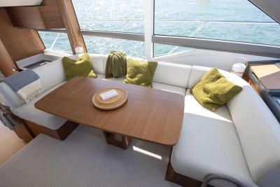 Luxurious 2022 Princess F50 yacht interior with cozy seating and elegant wooden table.