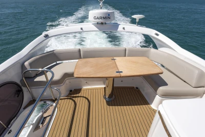 Luxurious 2022 Princess F50 yacht deck with seating and table, cruising on open water.