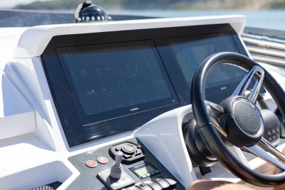 Steering wheel and dashboard of 2022 Princess F50 yacht with navigation screens.
