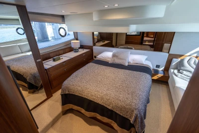 Luxurious bedroom interior of 2022 Princess F50 yacht with elegant wood finishes.