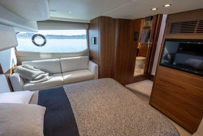 Luxurious 2022 Princess F50 yacht interior with cozy bedroom, sofa, and scenic window view.