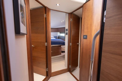 Luxurious interior of 2022 Princess F50 yacht with wooden doors and cozy bedroom.