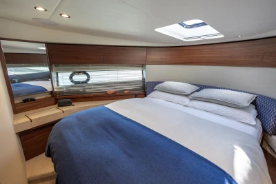 Luxurious bedroom interior of 2022 Princess F50 yacht with modern design and skylight.