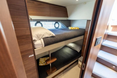 Luxurious 2022 Princess F50 yacht cabin with wooden interior and cozy bunk beds.