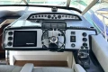 Control panel of a 2005 Princess V58 yacht with steering wheel and navigation equipment.