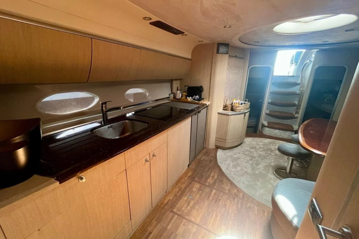 Luxurious interior of 2005 Princess V58 yacht with modern kitchen and dining area.