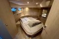 Luxurious cabin interior of 2005 Princess V58 yacht with cozy bed and porthole windows.