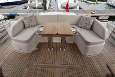 Luxurious seating area on 2025 Princess S65 yacht with wooden deck and elegant cushions.