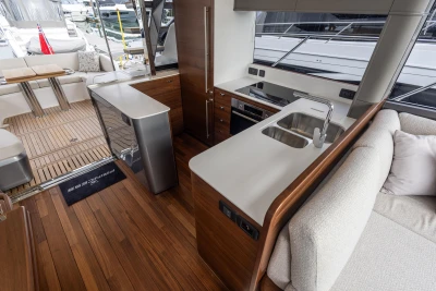 Luxurious interior of 2025 Princess S65 yacht featuring modern kitchen and seating area.