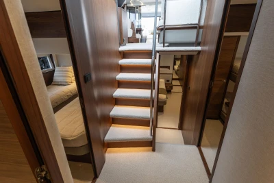 Luxurious interior of 2025 Princess S65 yacht with elegant wooden staircase and cozy cabins.