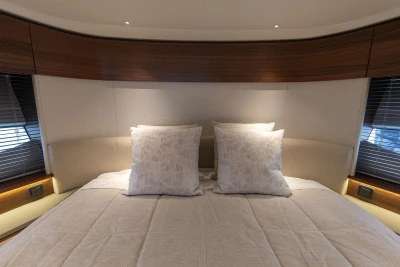 Luxurious bedroom interior of 2025 Princess S65 yacht with elegant bedding and wood accents.