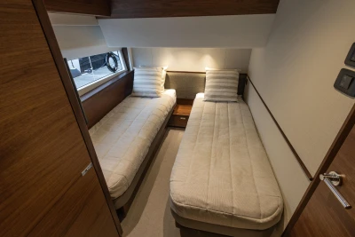Luxurious twin cabin interior of 2025 Princess S65 yacht, featuring modern design and cozy bedding.