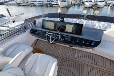 Luxurious 2026 Pricness F58 yacht helm with dual screens and elegant seating at marina.